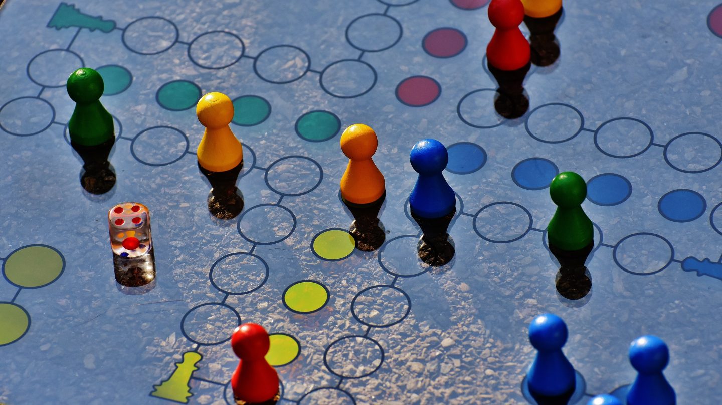 a dice, pieces and a board of dice representing a game in progress