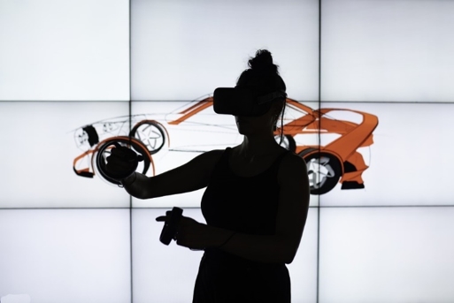 silhouette of woman experiencing VR content in front of a tiled display of a car illustration