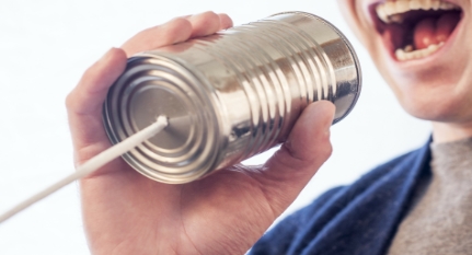 a man holding a can with a thread and talking into it for communication